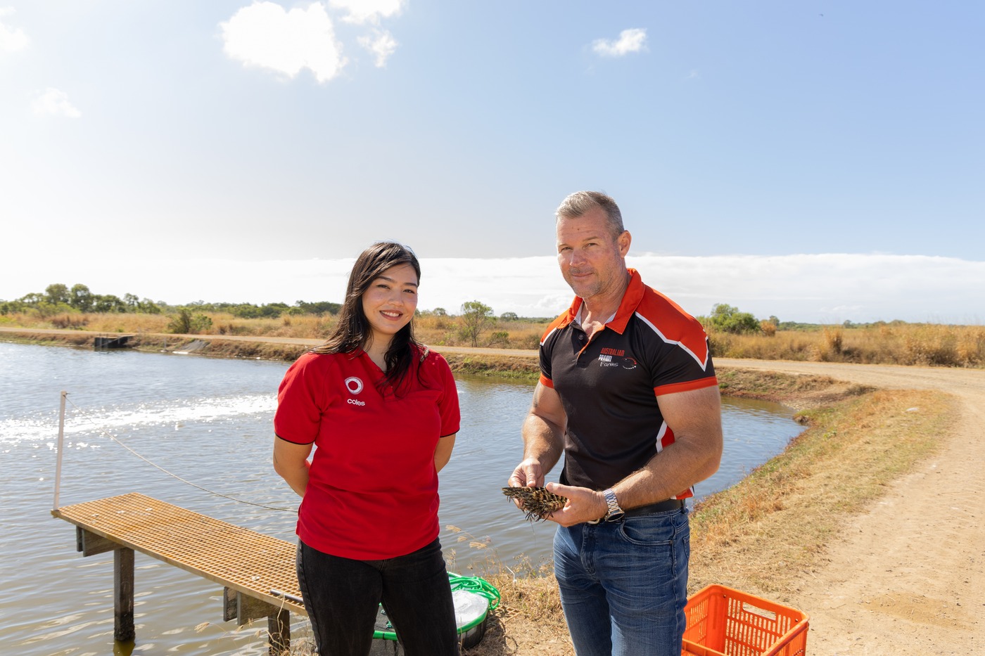 Australian Prawn Farms operator with fresh prawns at pond edge Ilbilbie