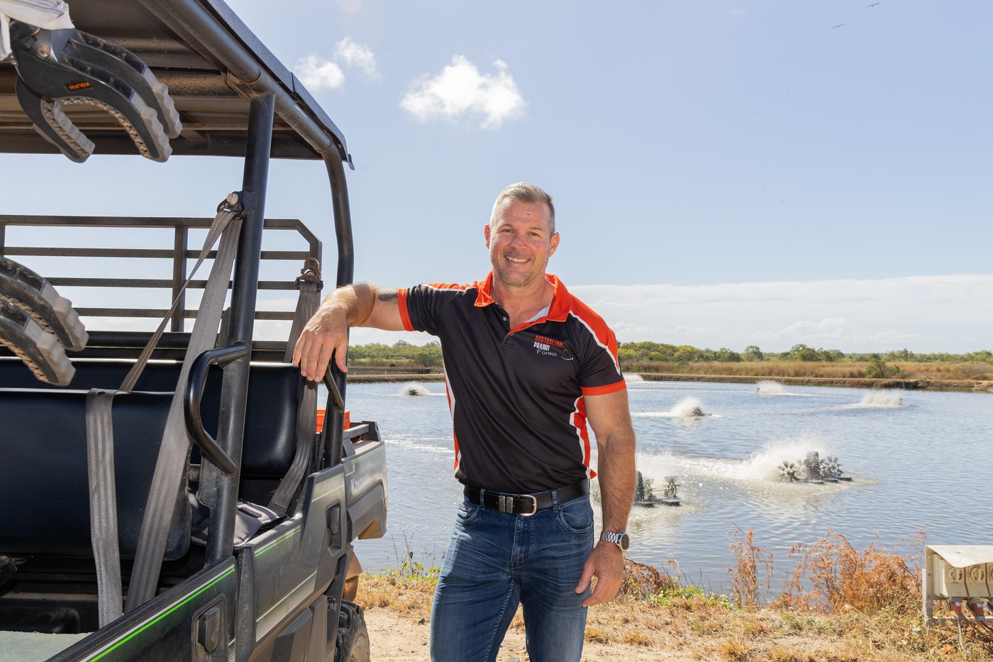 Australian Prawn Farms operator leaning on the farm buggy beside the grow-out ponds, Ilbilbie Queensland