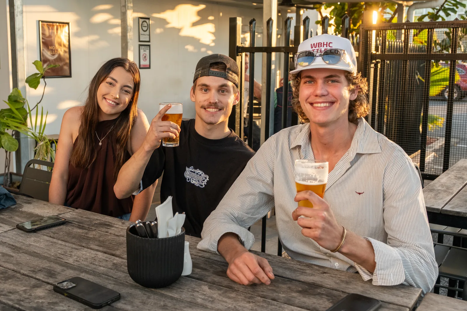 Patrons with beers in the outdoor area at The Metropolitan Hotel, Mackay, at golden hour