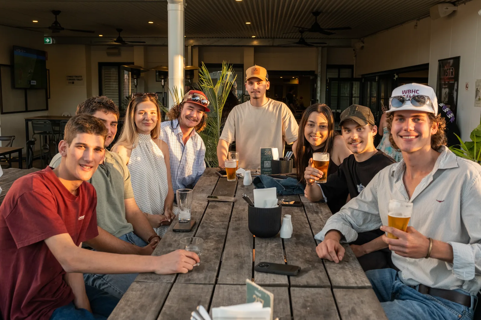 Group of friends at a long table in the beer garden at The Metropolitan Hotel, Mackay