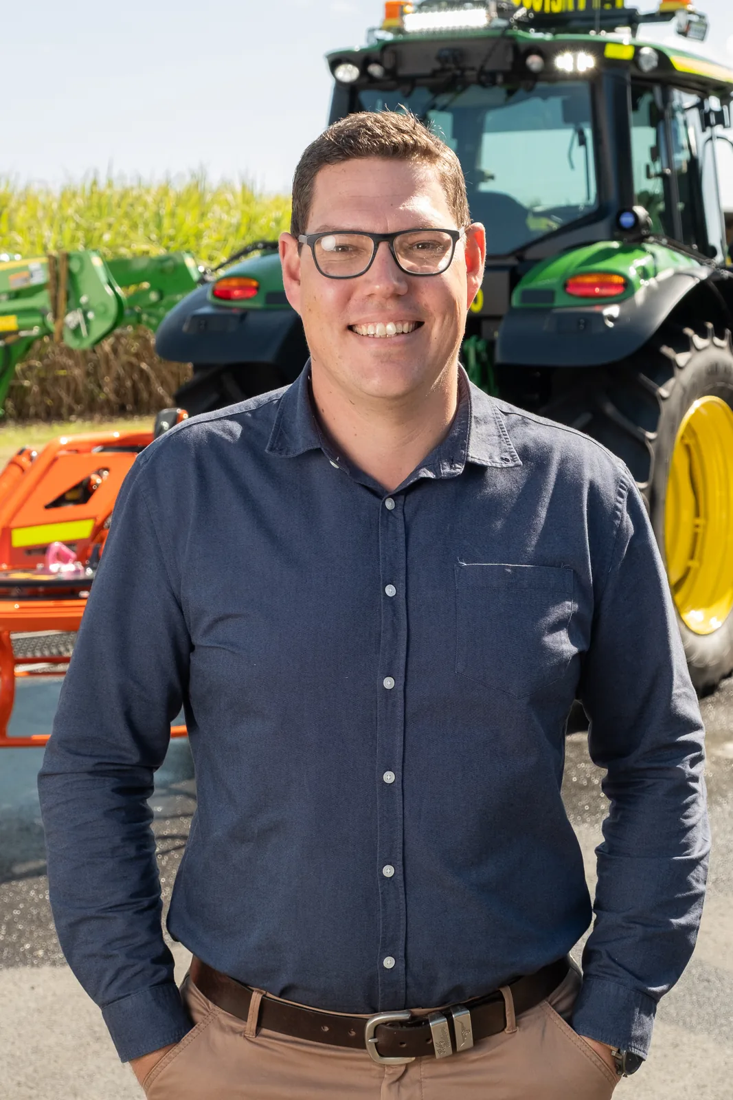 EHS Manufacturing team member in front of a John Deere tractor and fabricated equipment, Mackay