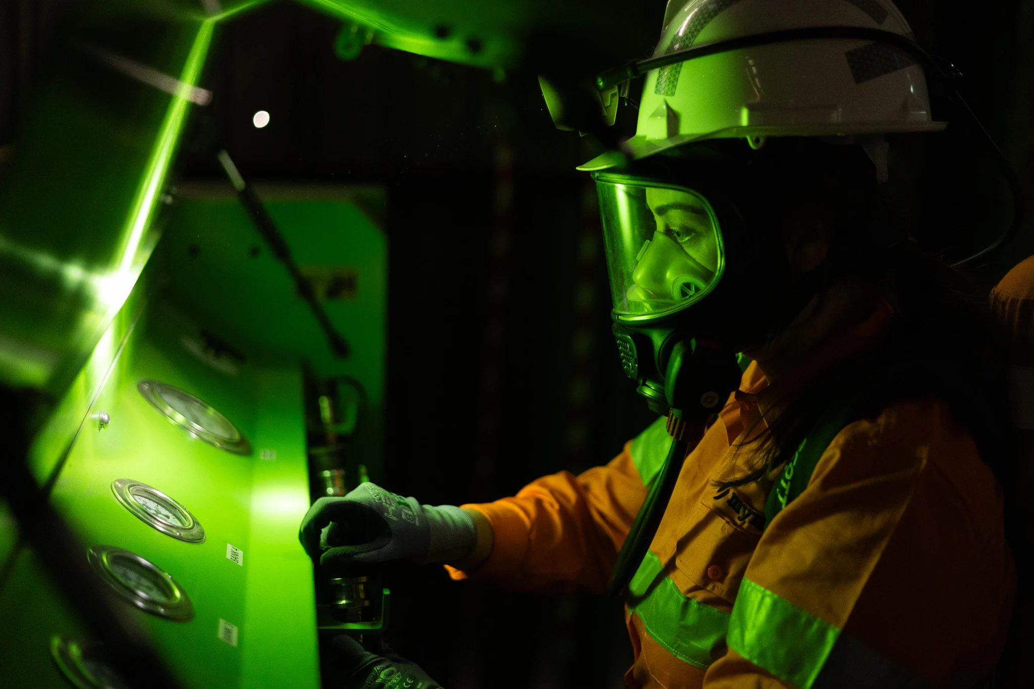 Worker in hard hat and full-face respirator at an equipment panel, photographed on a WorkPac Skills shoot by Jordan Cullen