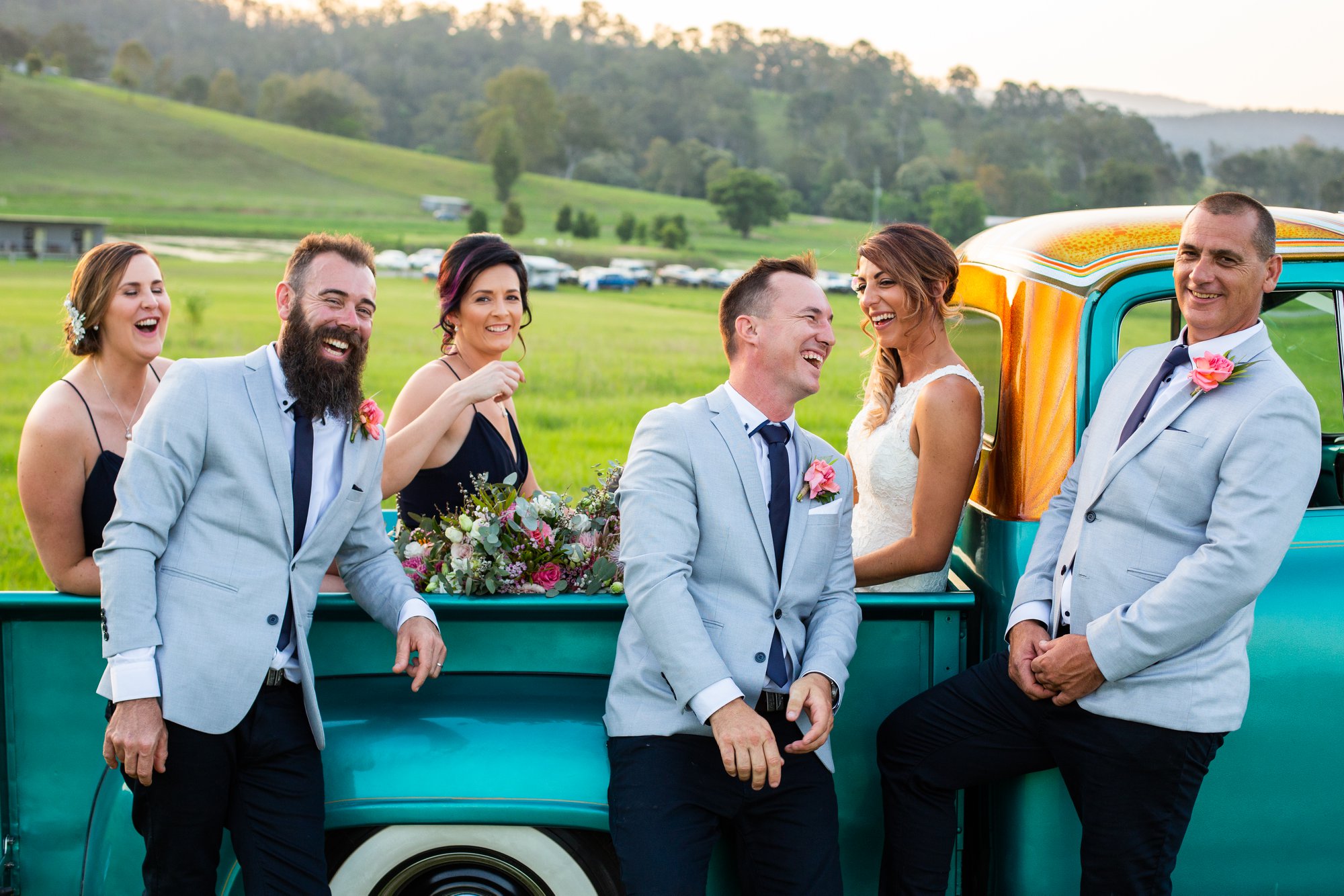 Bridal party at Mackay wedding laughing vintage truck